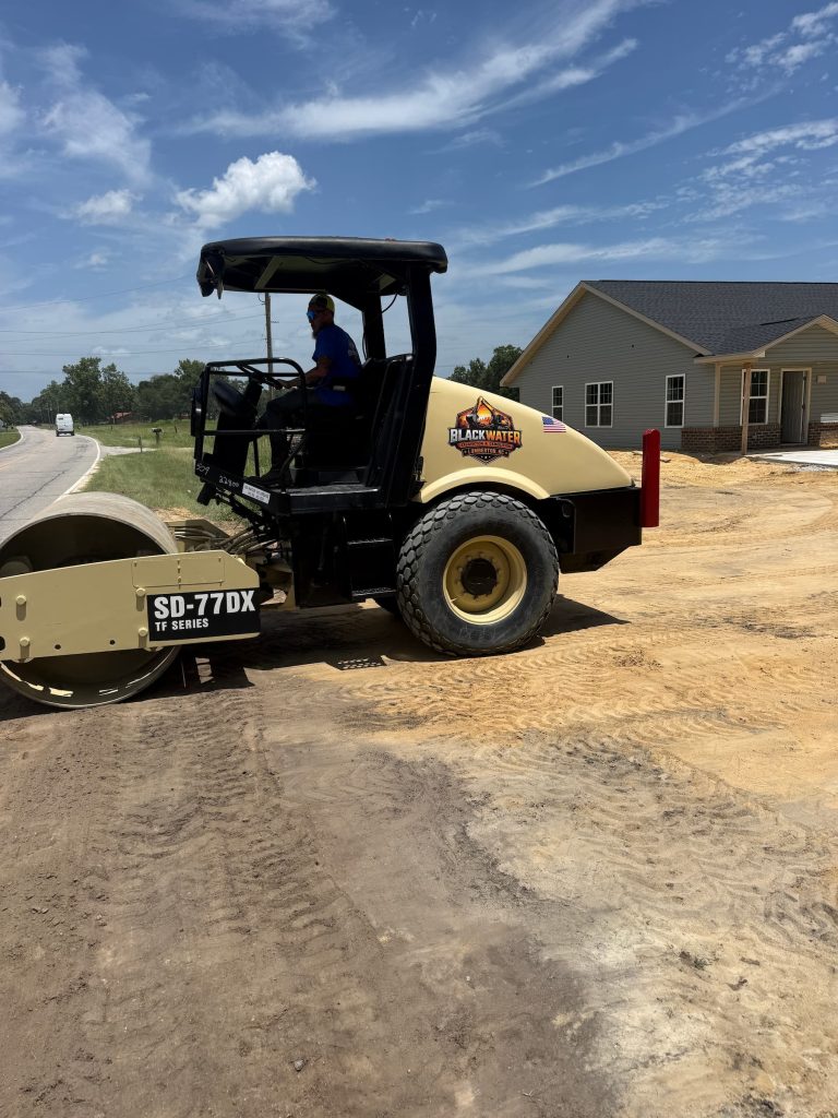 Black Water soil compactor roller preparing a building pad at a residential development